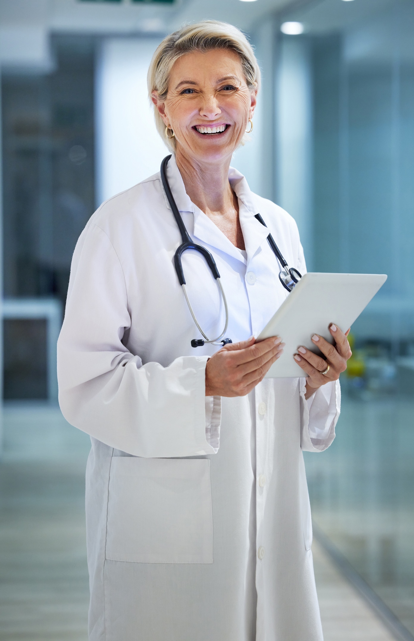Healthcare, tablet and portrait of senior doctor in hospital for wellness, medical care and support. Insurance, clinic and woman smile with digital tech for telehealth, research or online consulting for Scion Executive Search